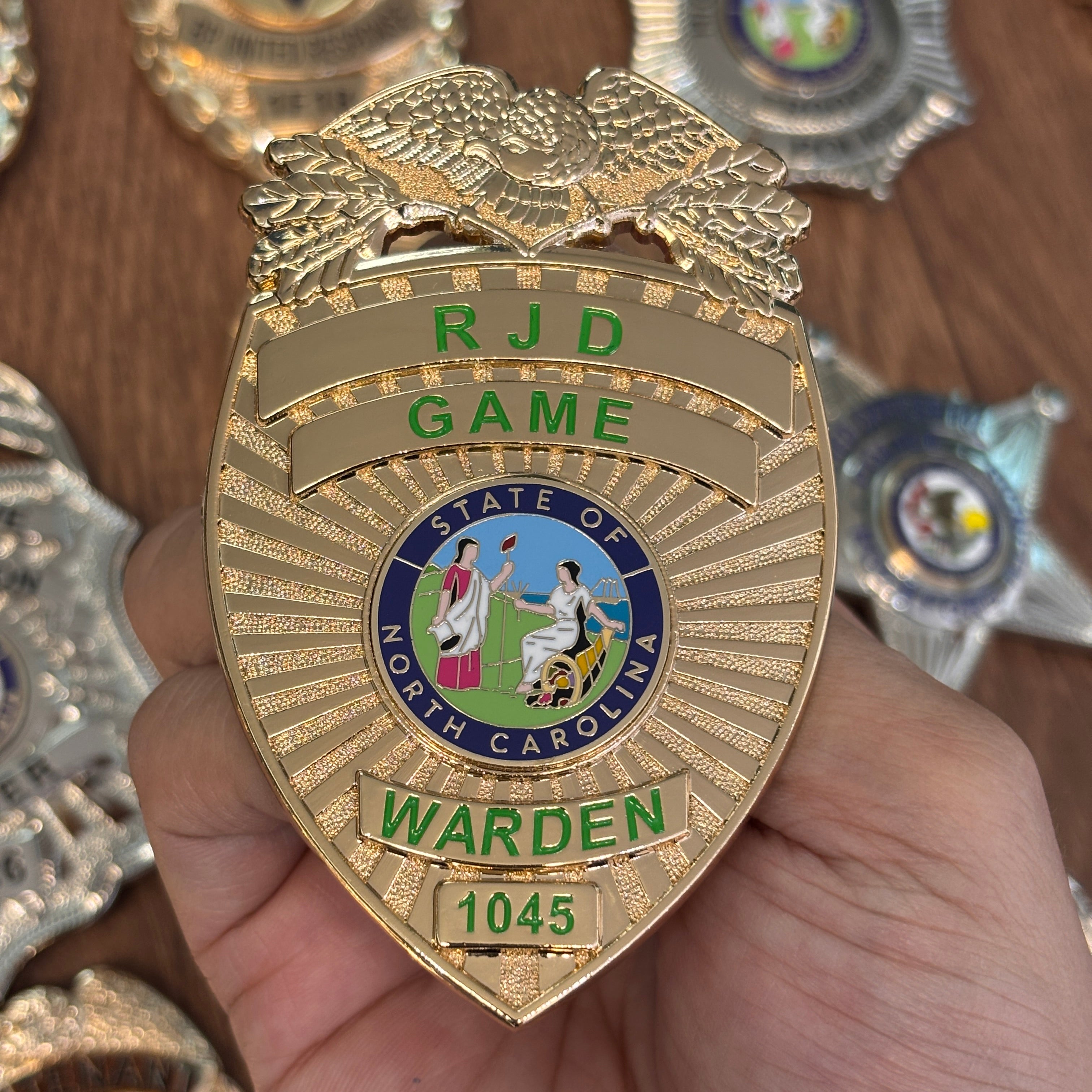 Gold-tone personalized metal badge with an eagle, North Carolina-inspired center emblem, green lettering, and custom identification number